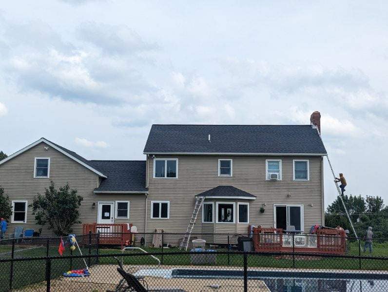 Roofing professionals on two-story home
