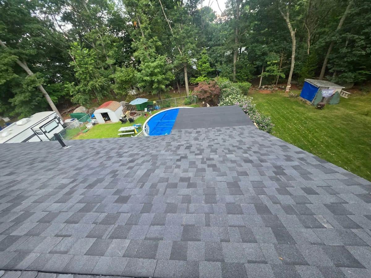 Coventry, RI roof with weathered, moss-stained brown shingles before, and new gray architectural shingles after, seen from above with the backyard pool behind