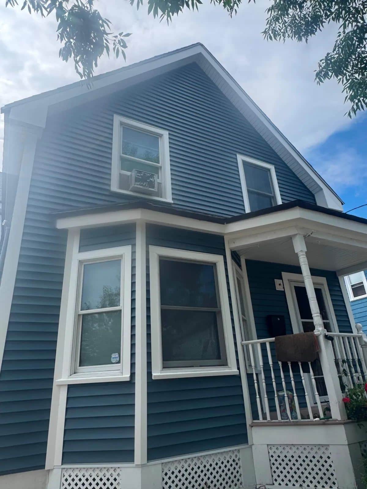 Front of an Everett, MA home with new blue clapboard siding and white porch trim