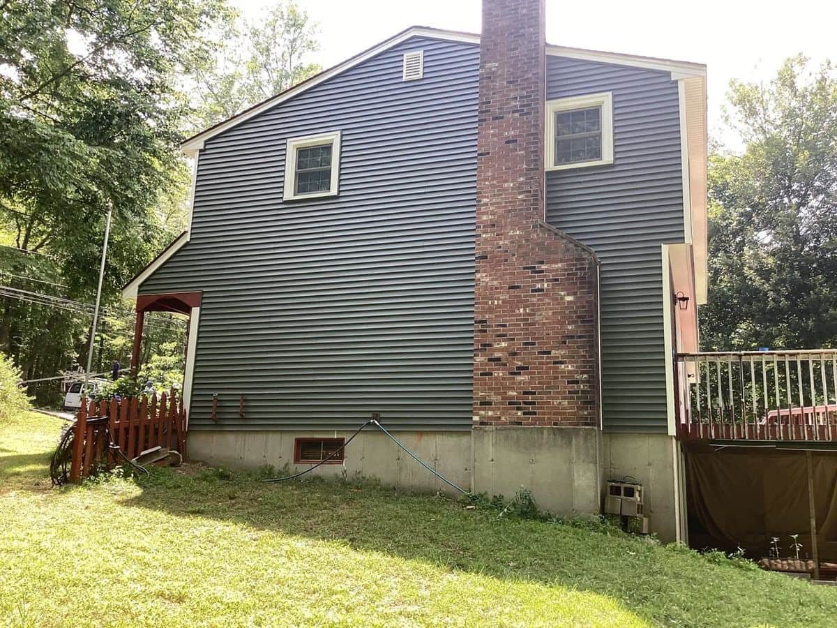 Rear of a Gales Ferry, CT home with new sage green clapboard siding and a brick chimney