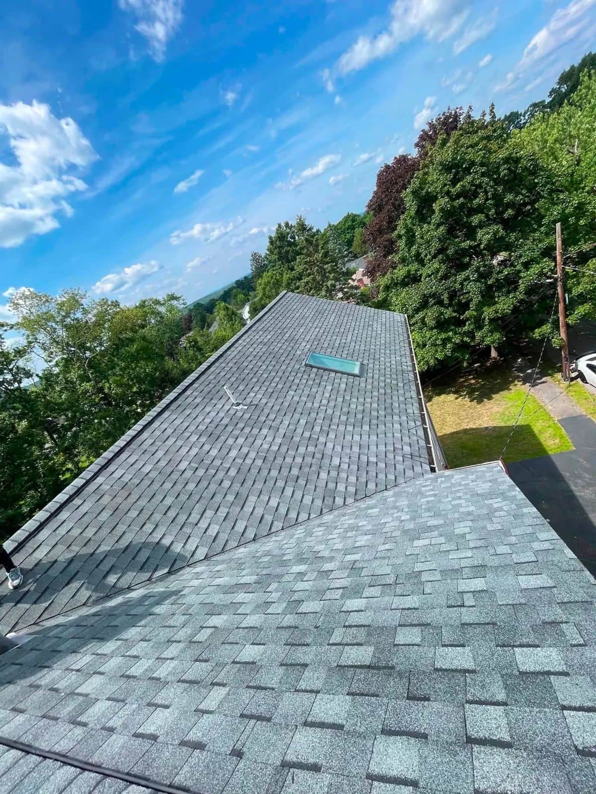 New gray shingle roof in Milton, MA under a blue sky