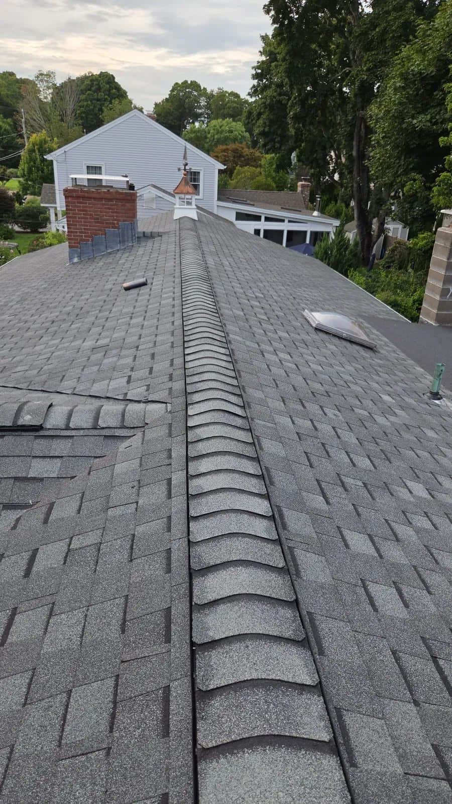 Rooftop view in Old Saybrook, CT showing a new gray shingle roof and chimney