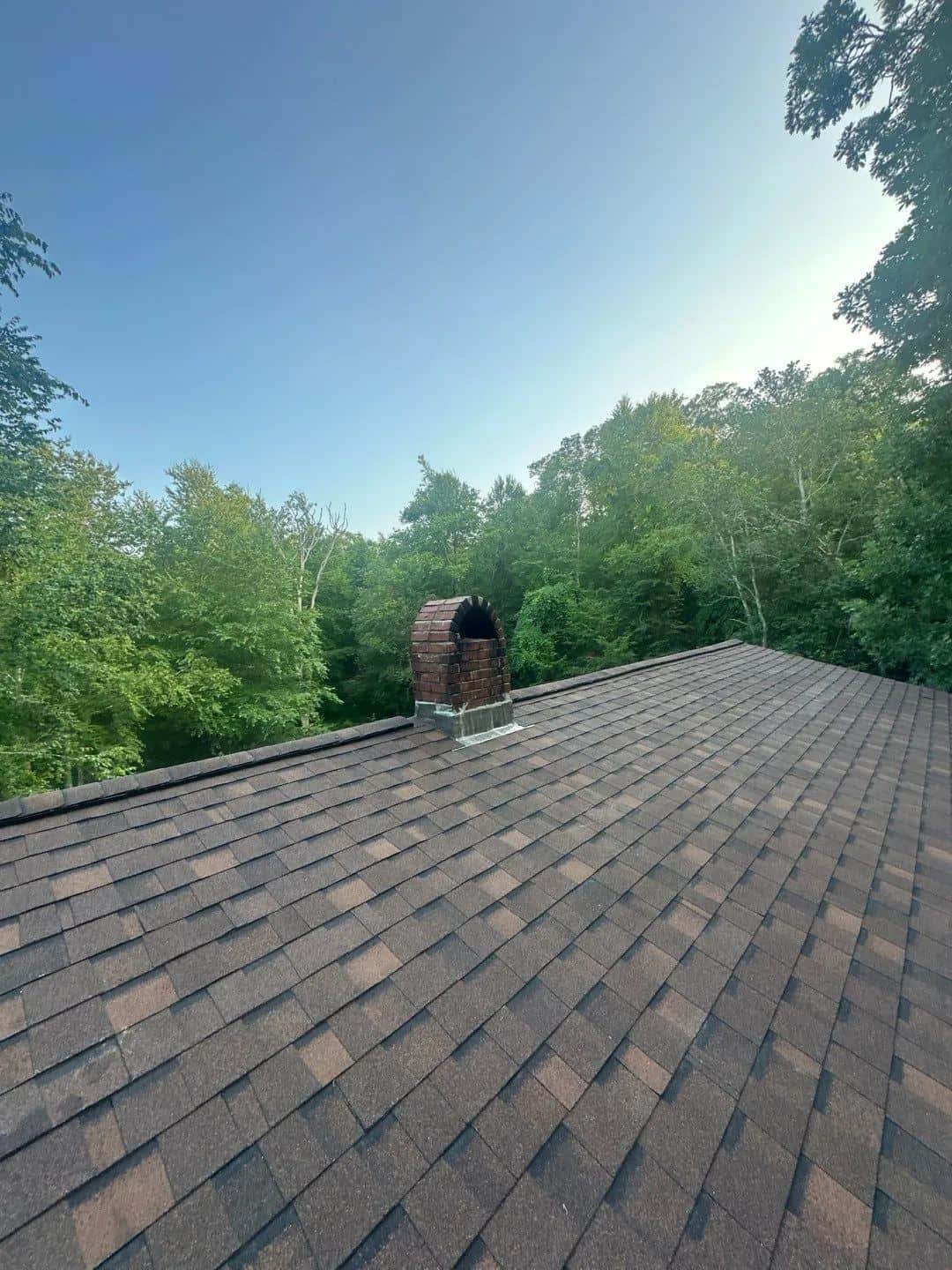 New brown architectural shingle roof in Richmond, RI with woods behind