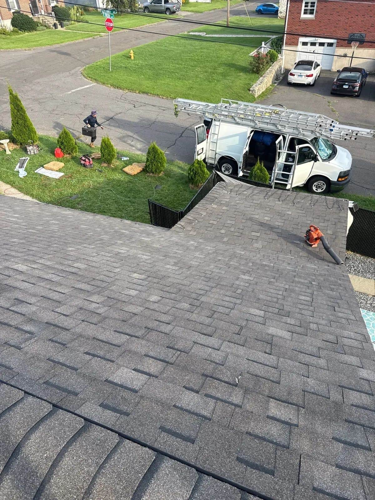 Overhead view of a new charcoal shingle roof in Watertown, CT with the crew's truck in the driveway