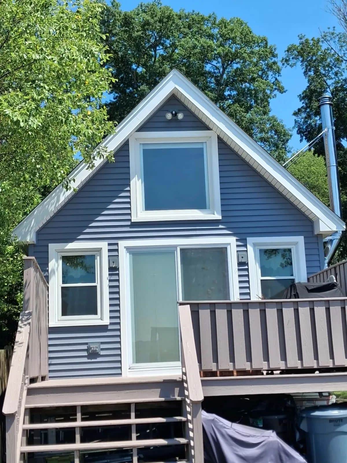 Rear of a Westport, MA home with new slate blue clapboard siding and a bay window