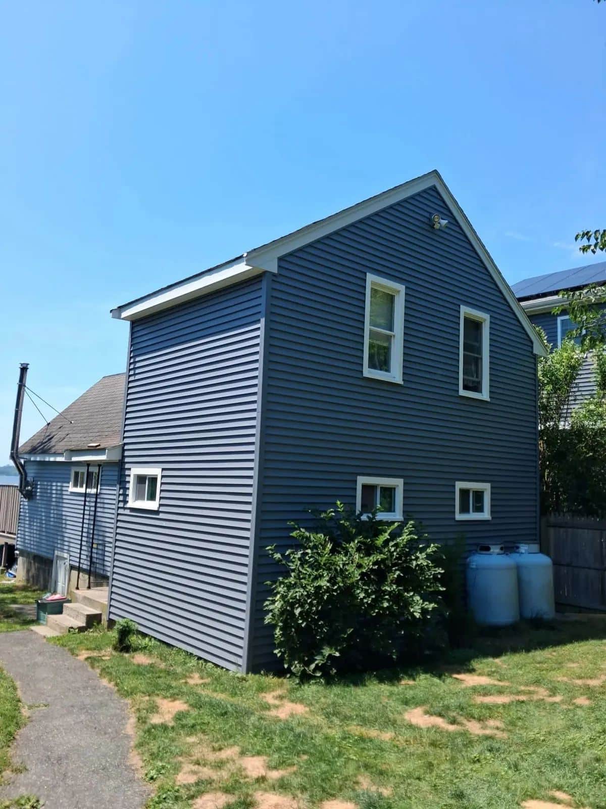 Side elevation of a Westport, MA home with new slate blue clapboard siding