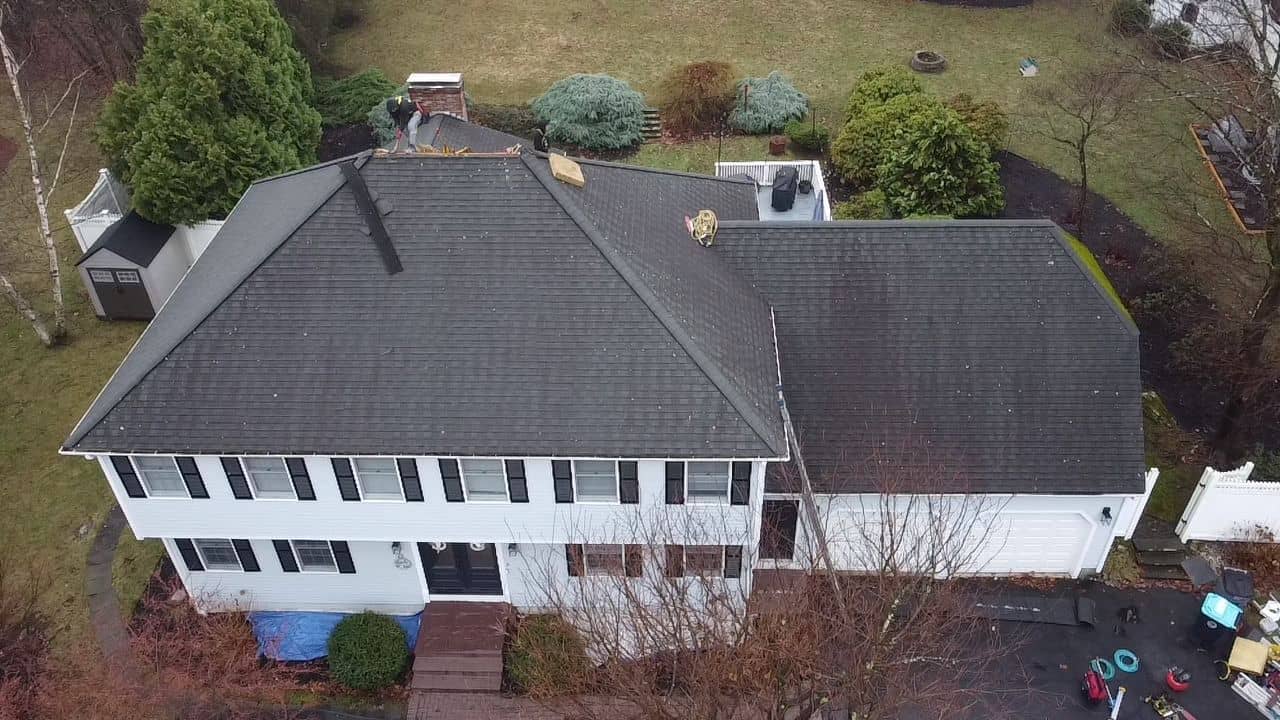 Shrewsbury, MA home during roof tear-off, with old shingles being removed