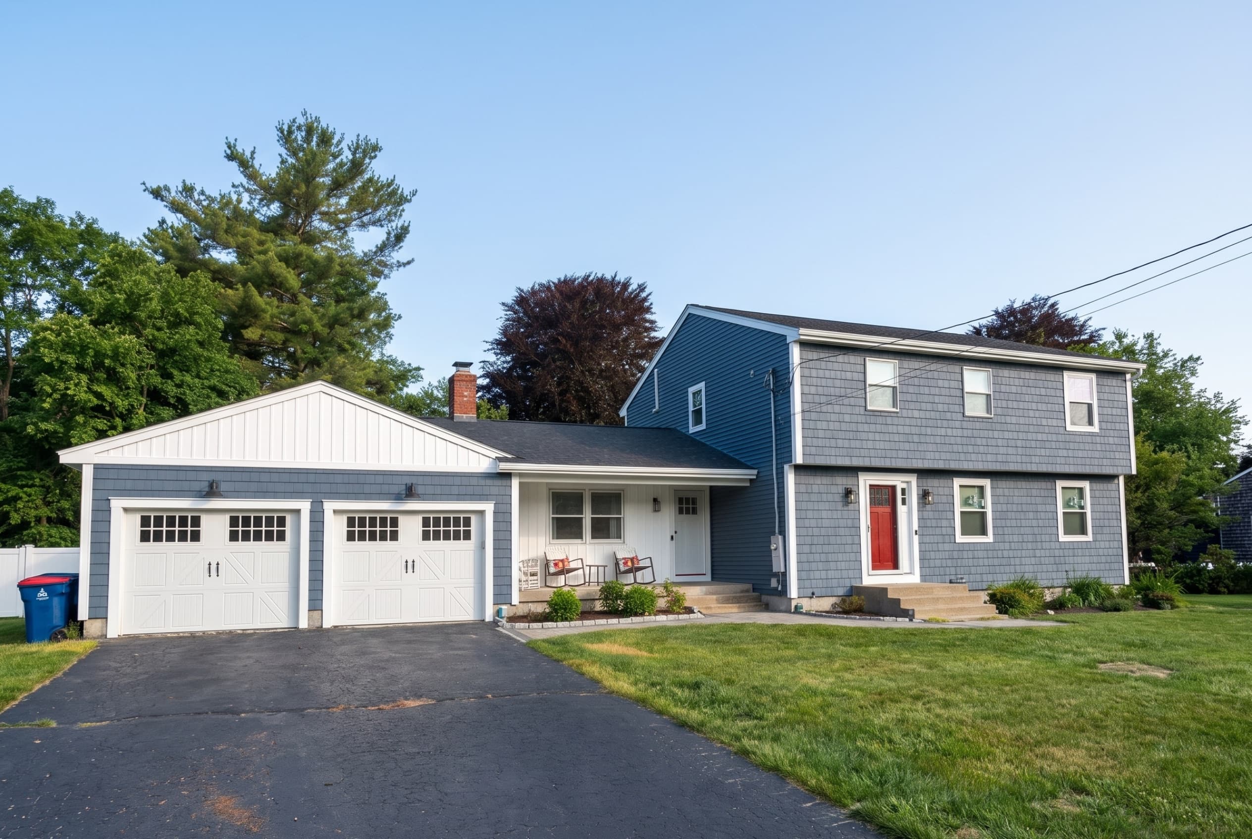 Blue-gray home with new shingle and lap siding, a white board-and-batten garage gable, and a red front door