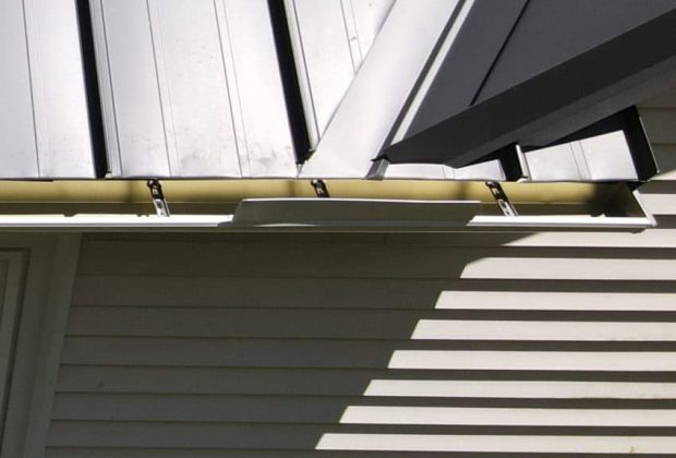 Metal roof vent and new gutters installed on a residential home roof for ventilation and weather protection.