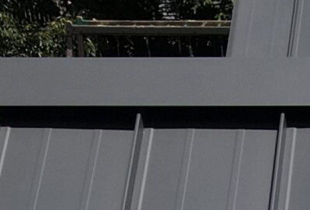 Galvanized metal roofing panels, durable outdoor roof with vertical seam design, weather-resistant construction, suitable for residential or commercial buildings.